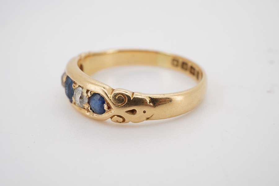 A late Victorian 18ct gold, three stone sapphire and two stone diamond set half hoop ring, size S, gross weight 4.8 grams.